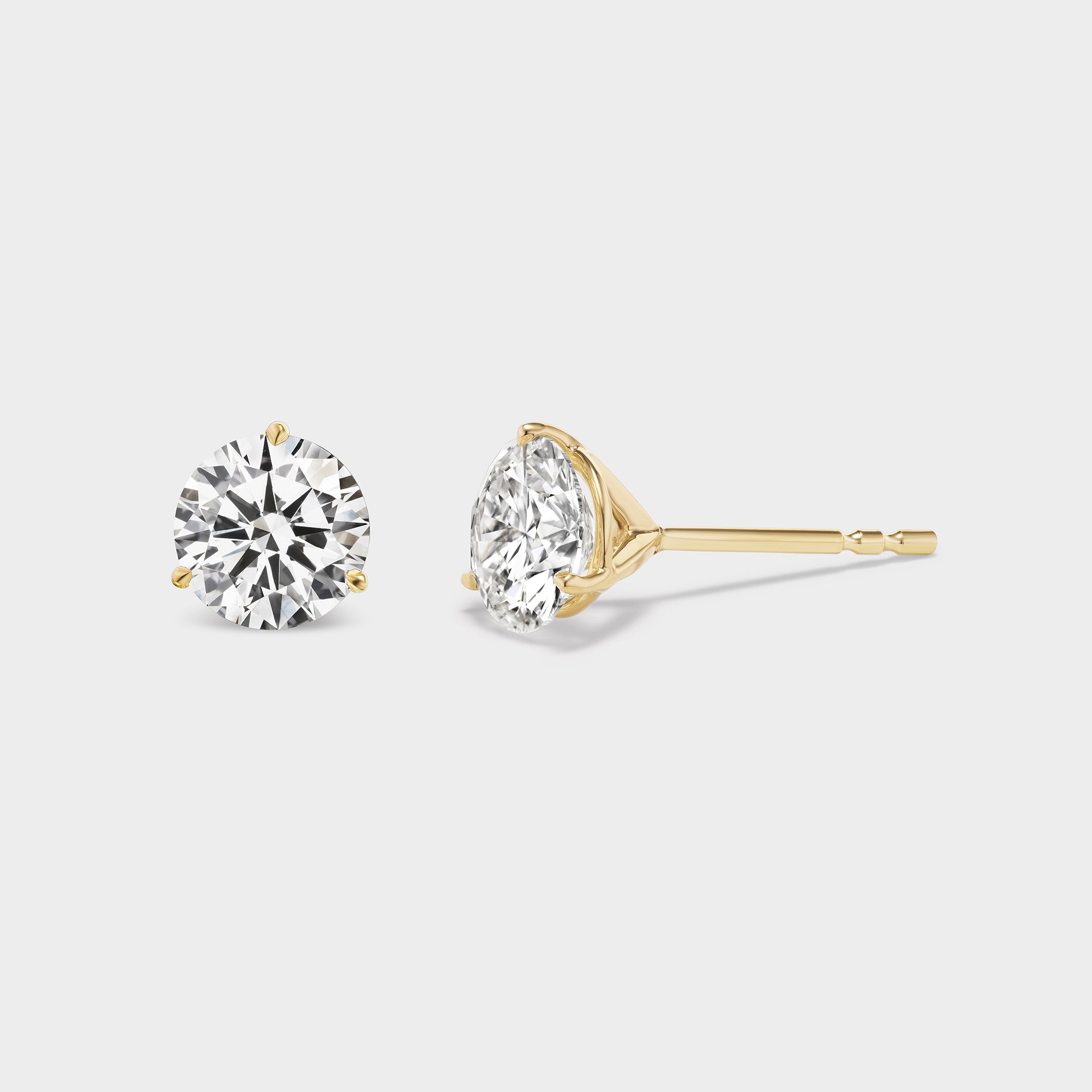 3 Prong Martini Diamond Studs. Close-up side view of a round diamond earring on a neutral background. Everyday sized lab diamond stud with modern setting in 14K white gold for school, work, events, or nights out. For a sophisticated woman with great taste. 