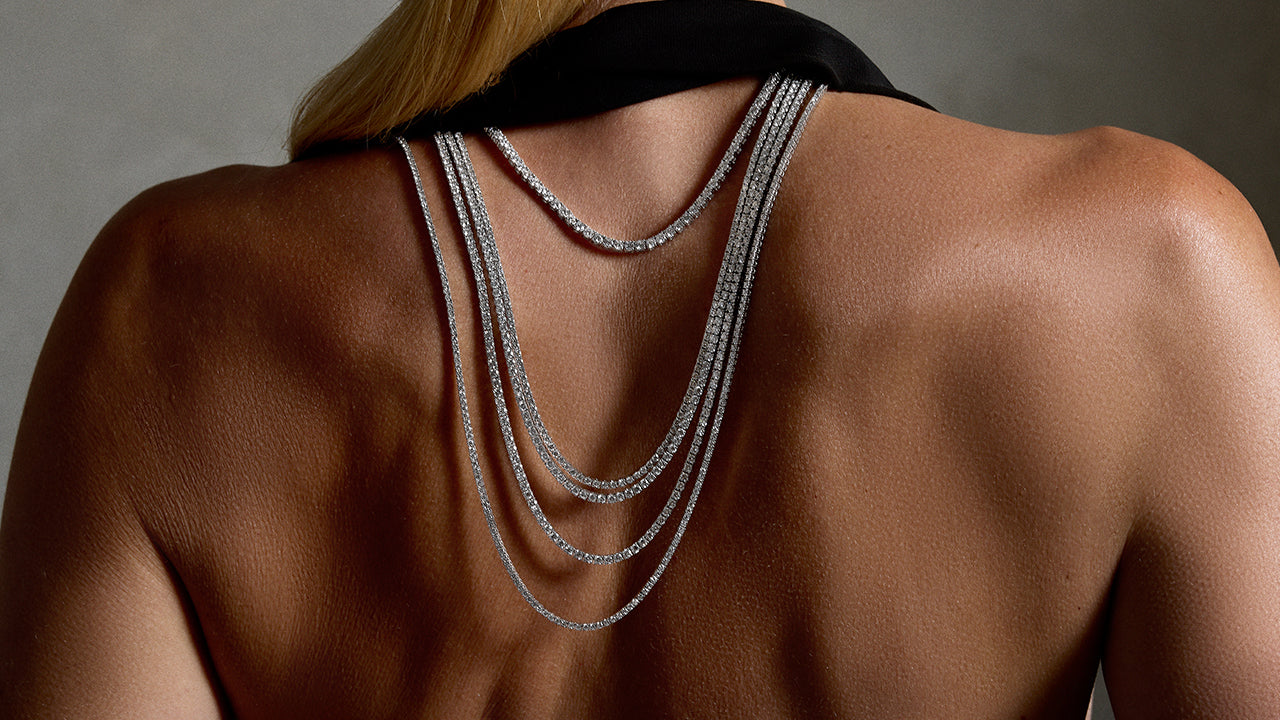 Model shown wearing layered Fiametta classic tennis necklaces in 14K white gold and diamonds.