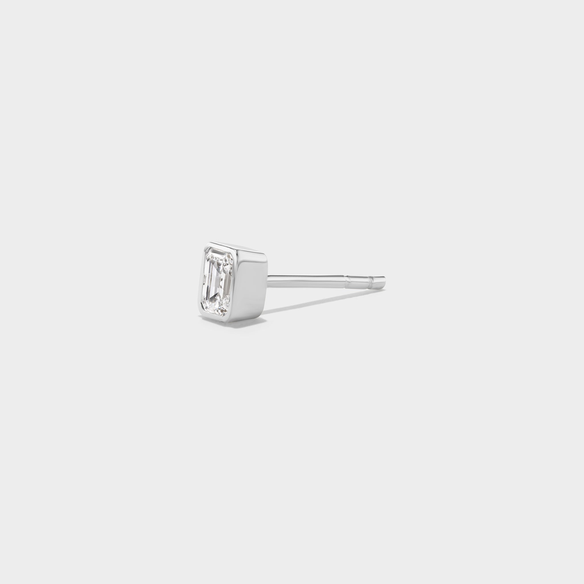 White gold mini stud with an emerald-cut lab diamond in a sleek bezel, perfect for an everyday ear stack.