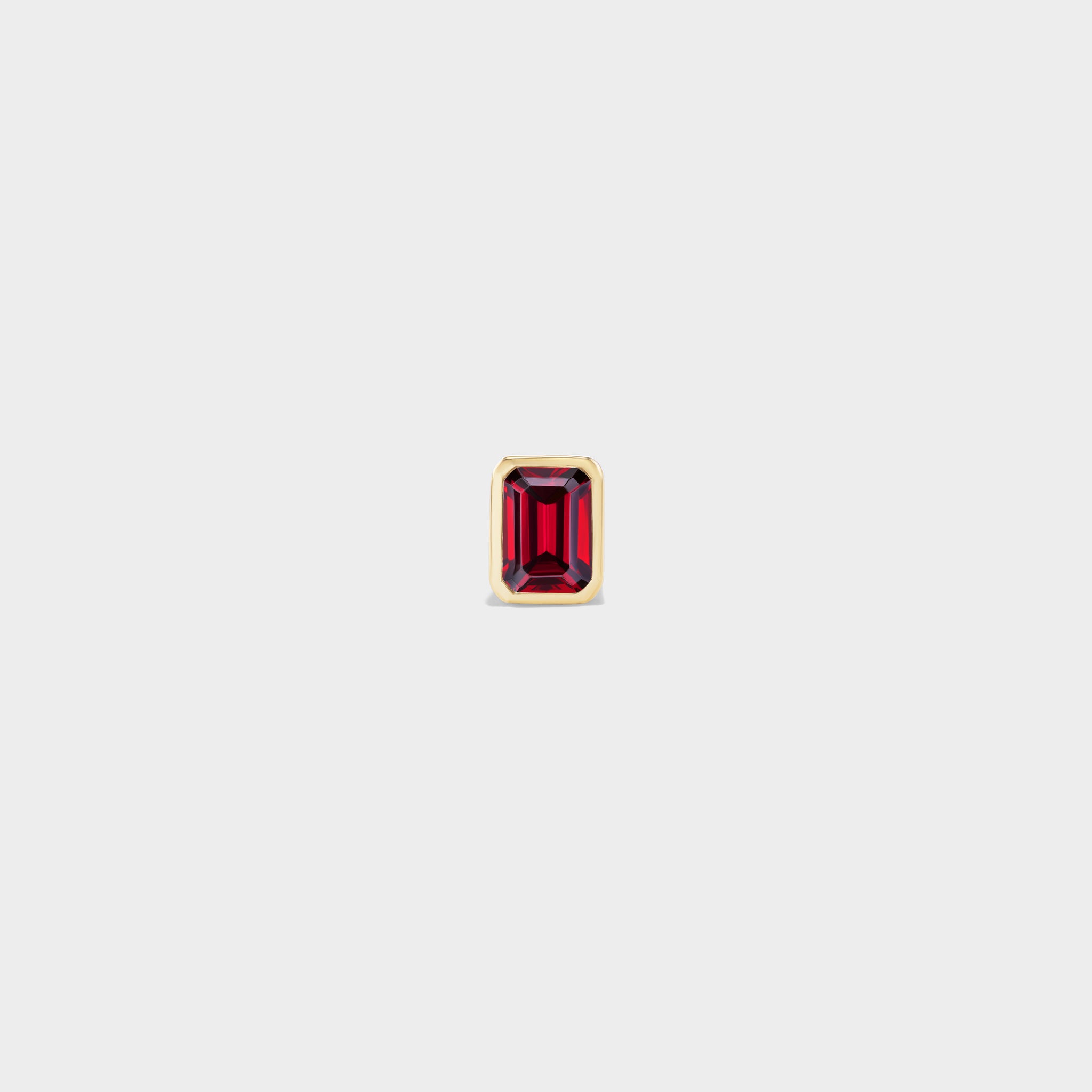 Everyday mini stud: emerald-cut ruby in a sleek yellow gold bezel, perfect for ear stacks.