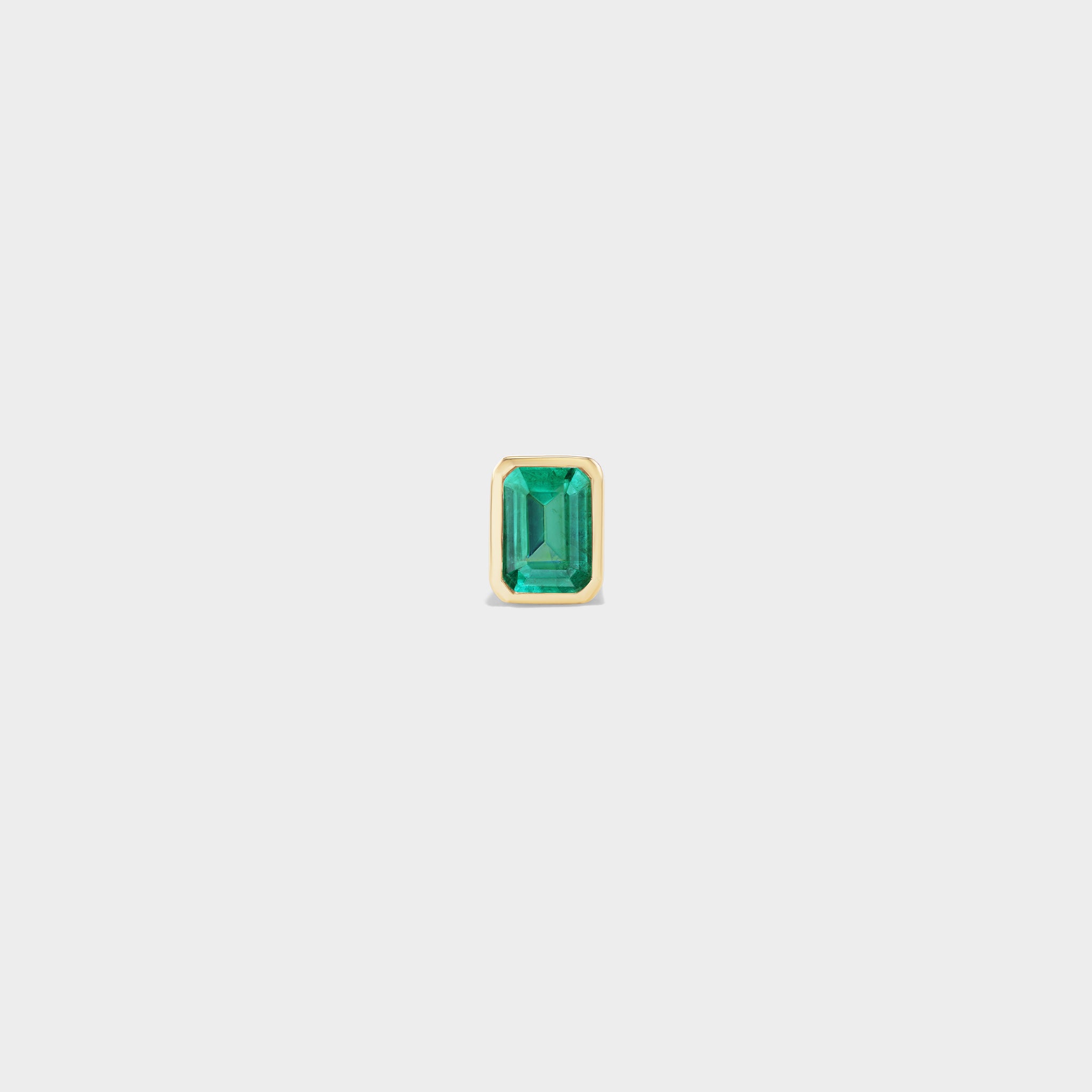 Mini emerald-cut emerald stud in 14k yellow gold, bezel-set for everyday wear or ear stacks.