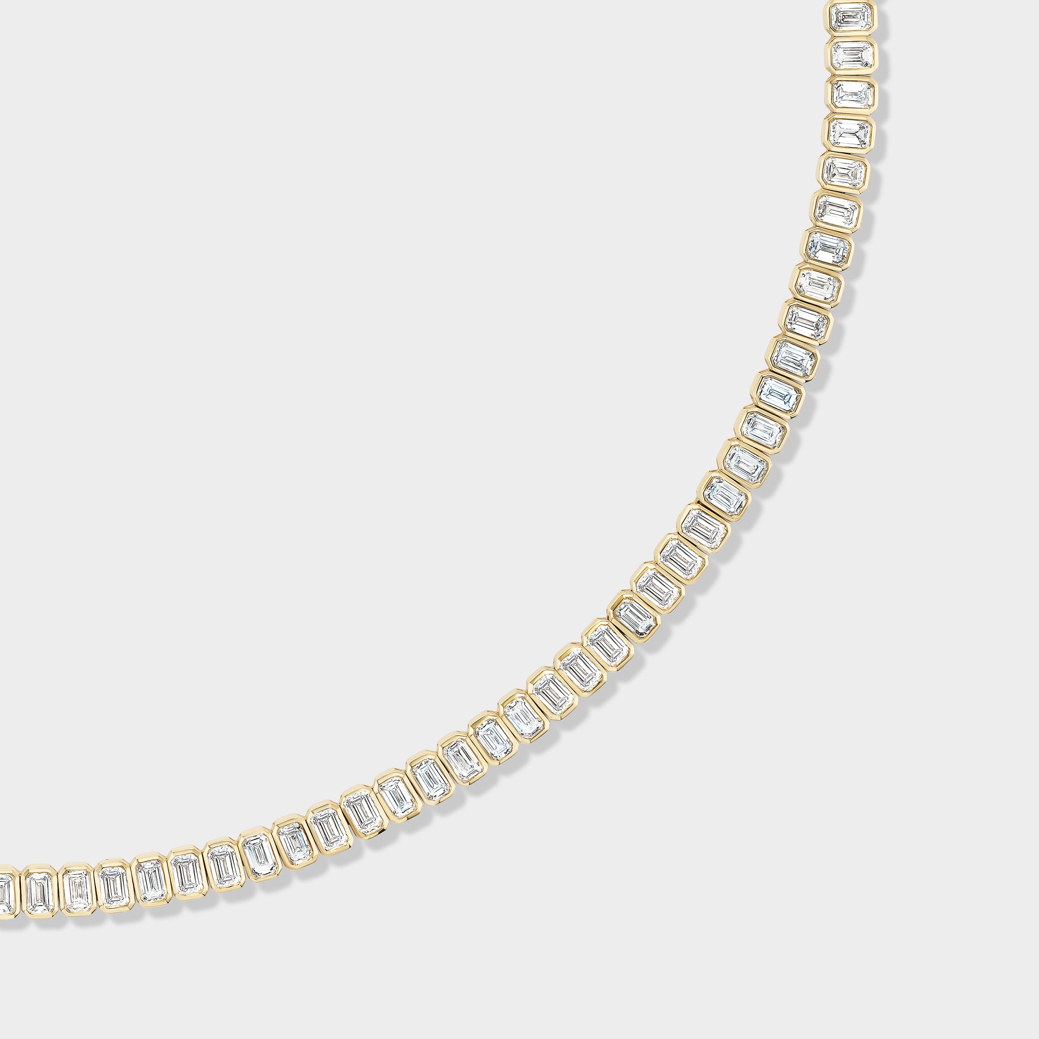Emerald-cut lab-grown diamonds in a bezel-set 14K gold tennis necklace, perfect for everyday elegance.