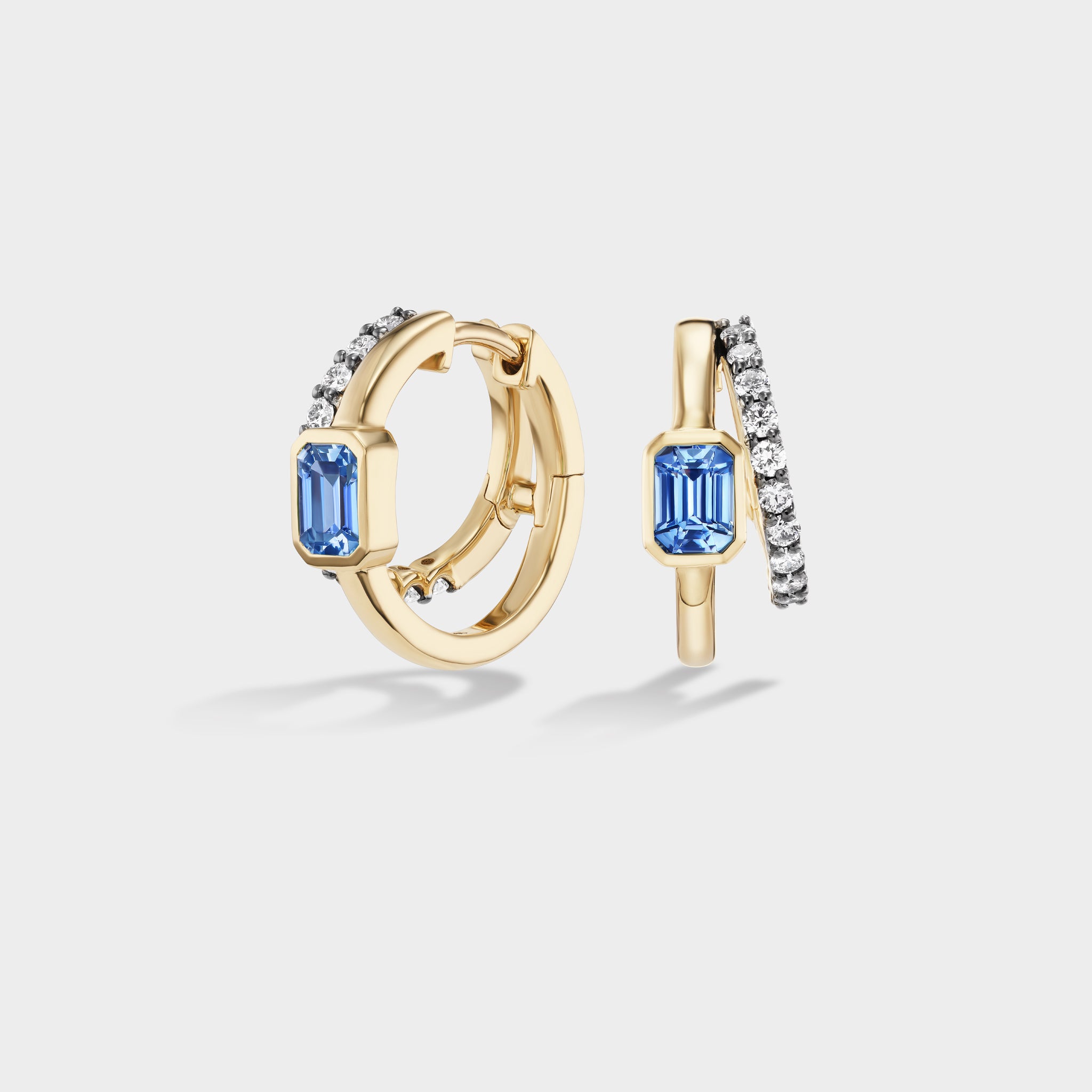 Yellow gold double huggie earrings with a bezel-set emerald-cut blue sapphire and pavé lab diamonds.