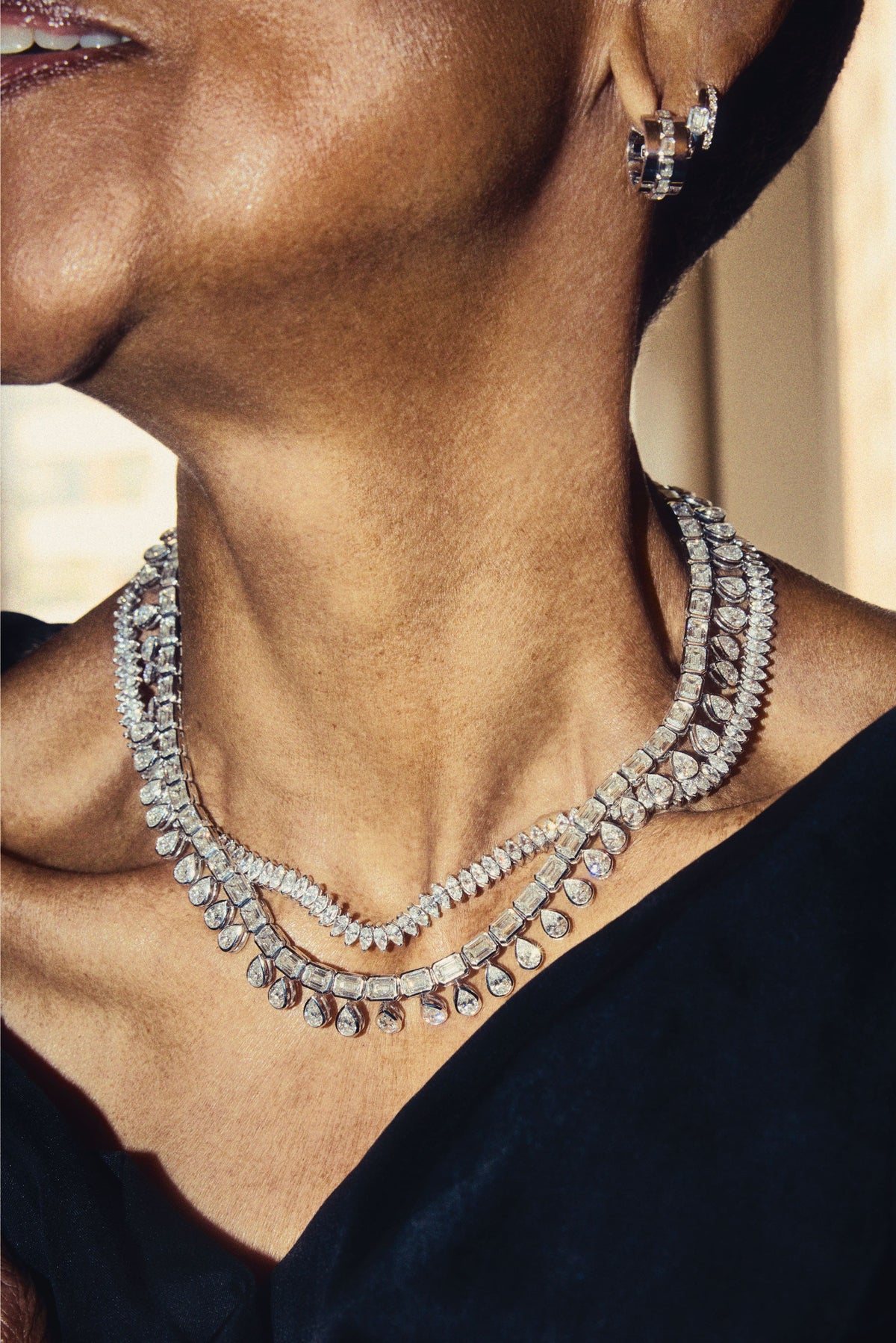 Model wearing Fiametta emerald-cut lab-grown diamond double hoop huggie earrings in 14k recycled white gold with pavé diamond accents, and multiple tennis necklaces with unique diamond shapes. Fiametta modern luxury fine jewelry combines old-world craftsmanship with ethical lab-grown diamonds for the modern collector with a unique point of view.