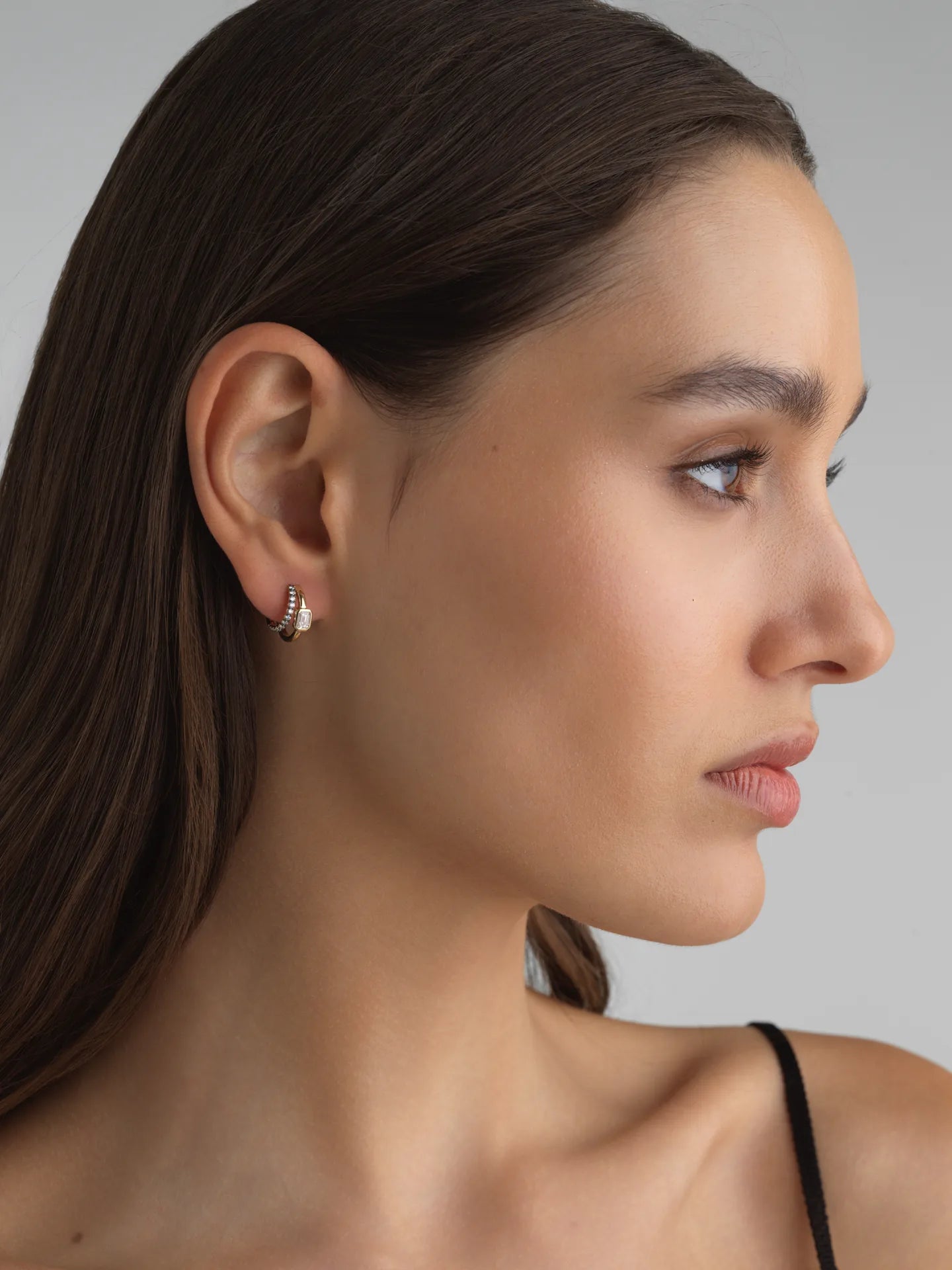 Model wearing Fiametta emerald-cut lab-grown diamond double hoop huggie earrings in 14k recycled yellow gold with pavé diamond accents, modern luxury fine jewelry combining old-world craftsmanship with ethical lab-grown diamonds. For the modern collector. An everyday style with a unique point of view.