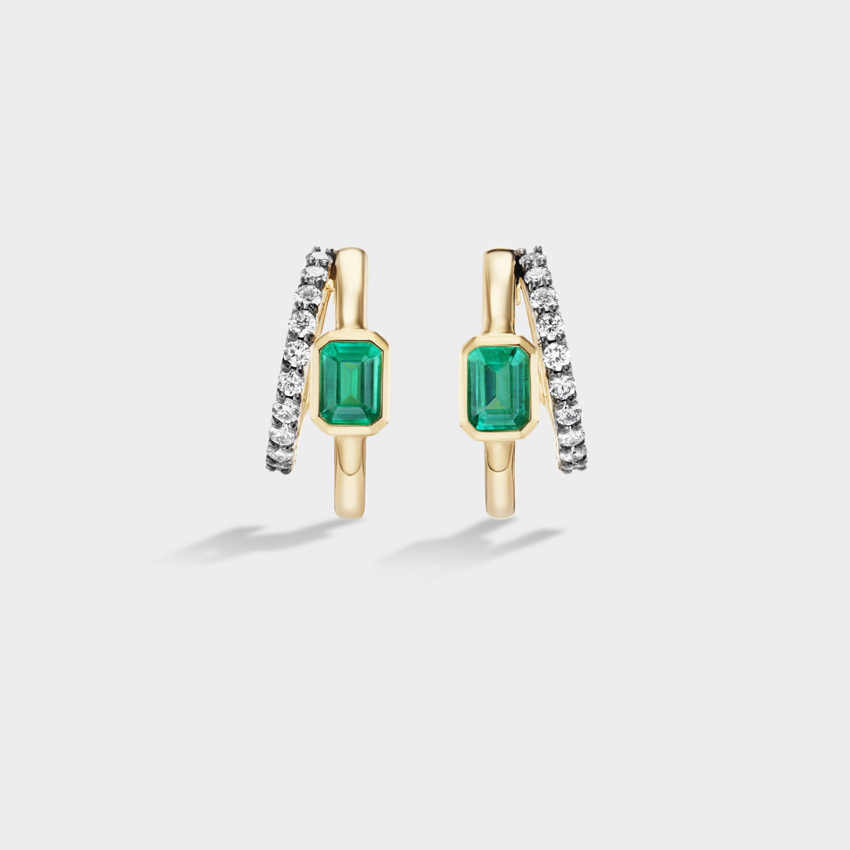 Fiametta emerald-cut lab-grown diamond double hoop huggie earrings in 14k recycled yellow gold with pavé diamond accents and natural green emerald, modern luxury fine jewelry combining old-world craftsmanship with ethical lab-grown diamonds. For the modern collector. An everyday style with a unique point of view.