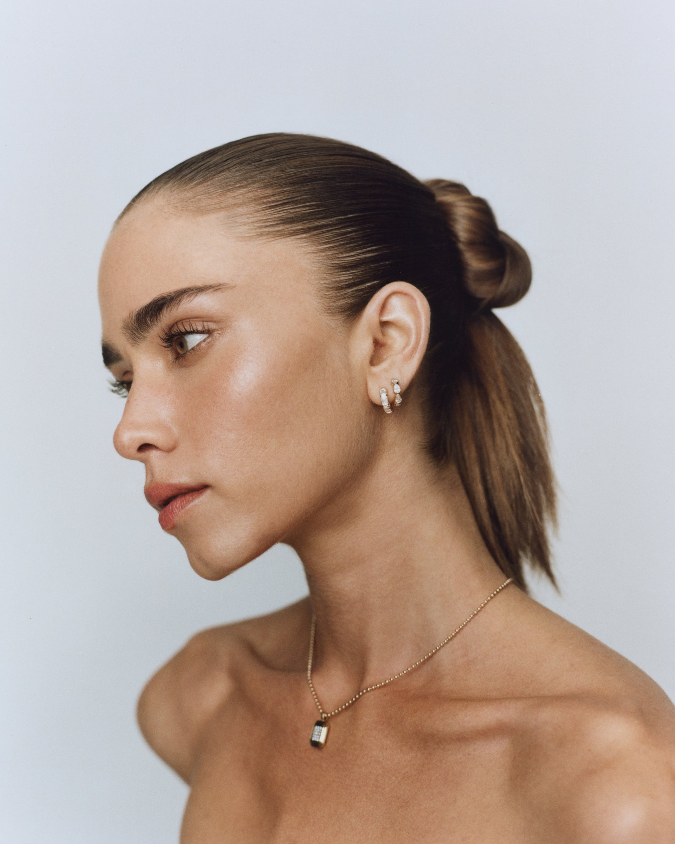 Mini emerald bezel huggies with natural rubies in 14k yellow gold, perfect for an ear stack.