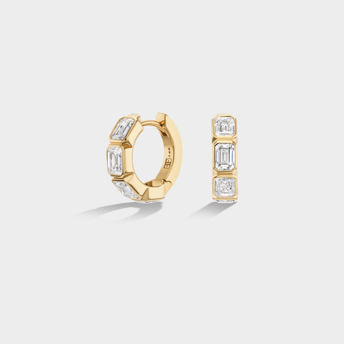 Mini 14K yellow gold huggie hoops with bezel-set emerald-cut lab-grown diamonds, ideal for an everyday ear stack.