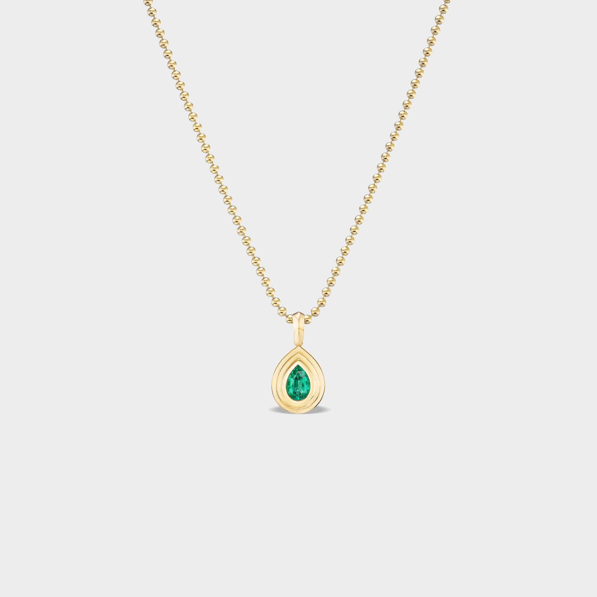 14K gold mini pear bezel charm with natural emerald, perfect for everyday wear.