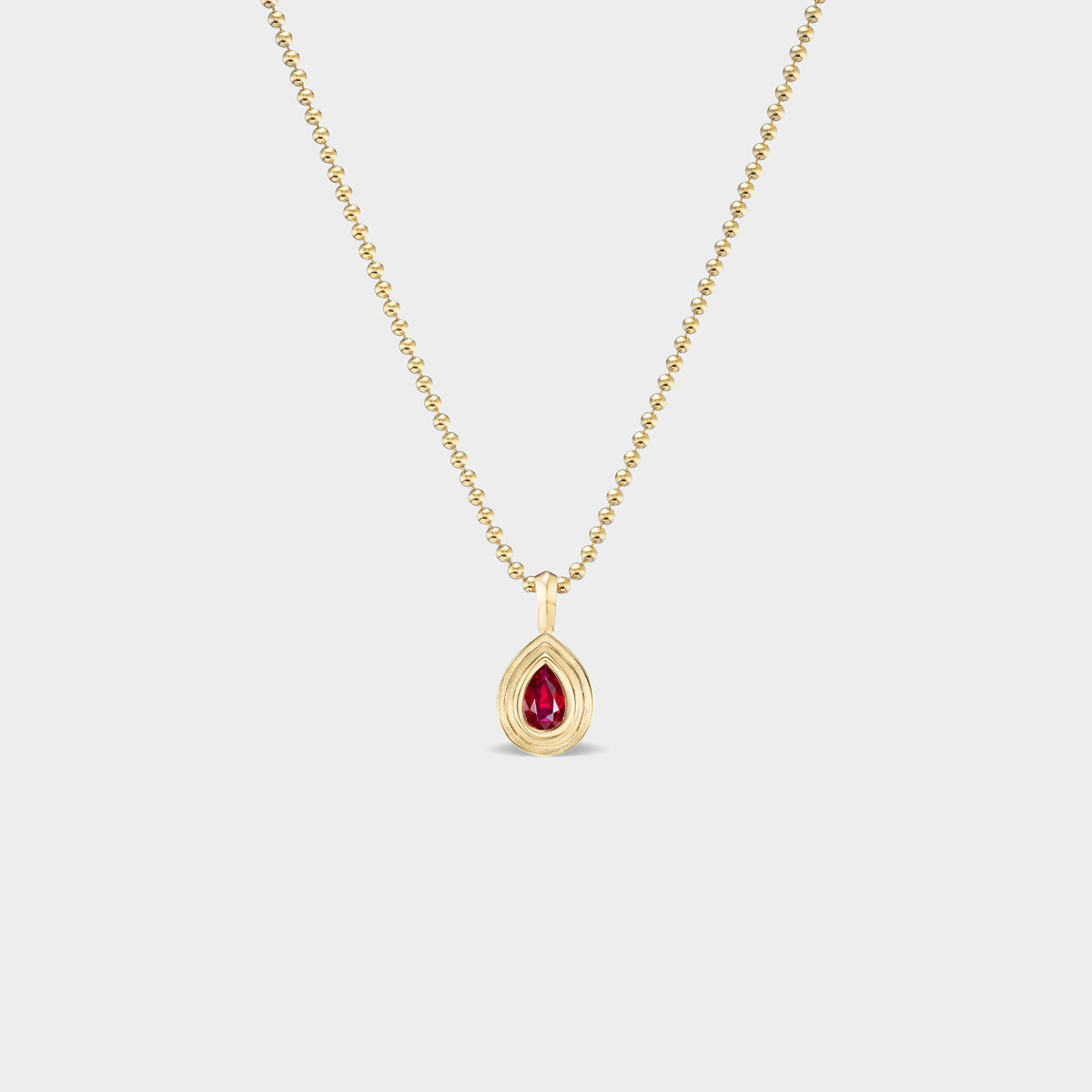 14K gold Mini Pear Bezel Charm with natural ruby, perfect for everyday wear.