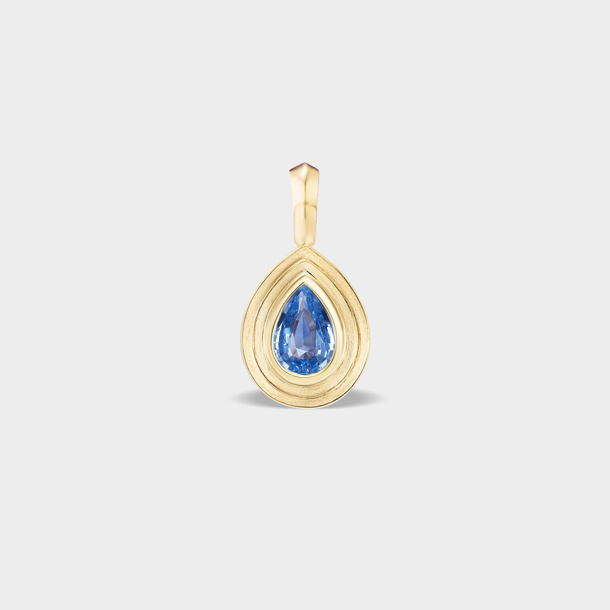 Mini 14K gold pear bezel charm with a natural blue sapphire, perfect for everyday wear.