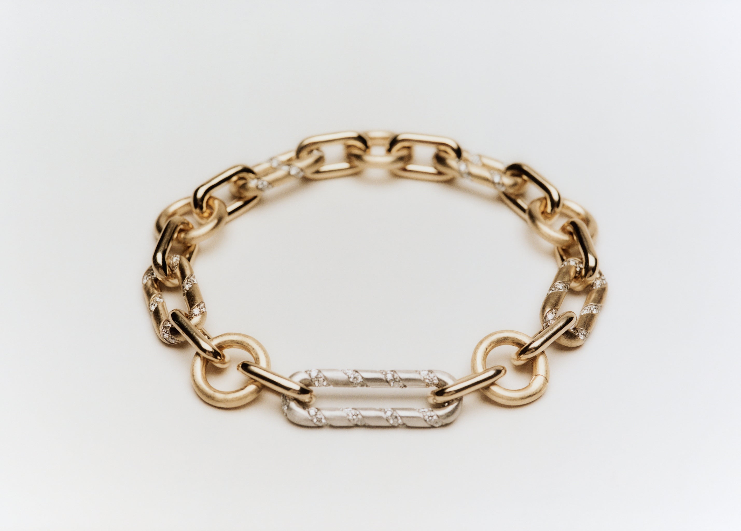 Mixed link bracelet in 14k yellow and white gold with lab-grown diamond links and a charm clip.