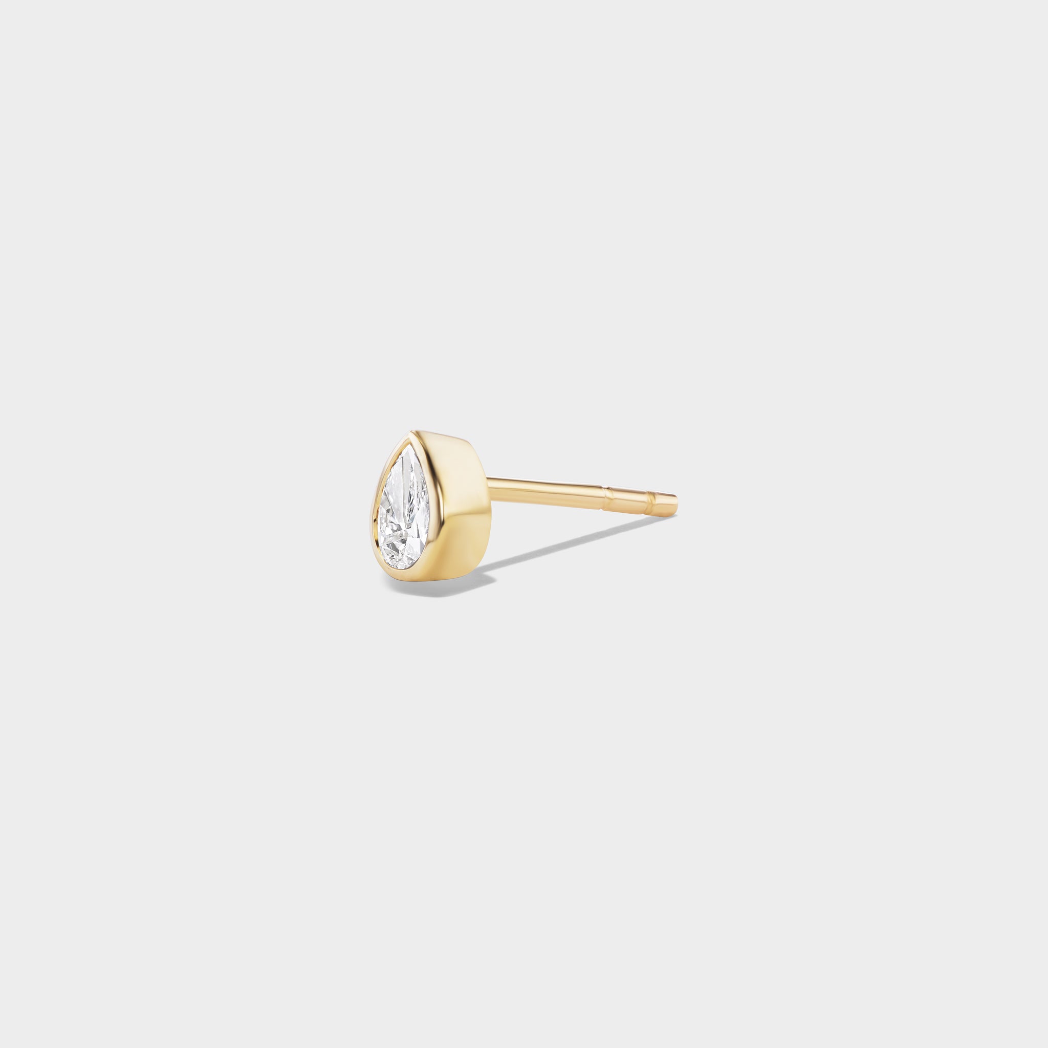 Everyday pear-cut lab diamond stud in 14K yellow gold with a modern bezel setting, perfect for ear stacks.