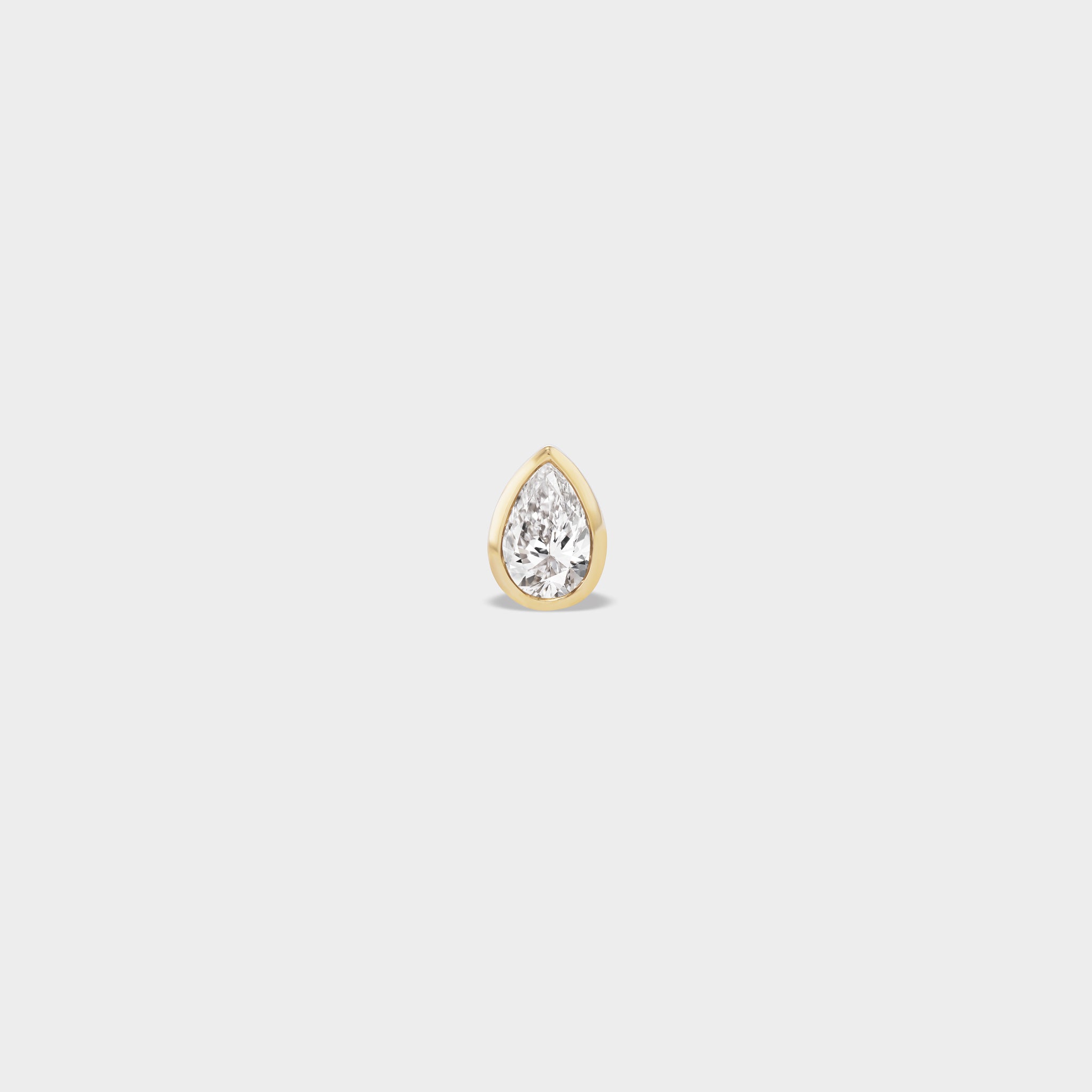 Everyday pear-cut lab diamond stud in 14k yellow gold bezel setting, ideal for an ear stack.