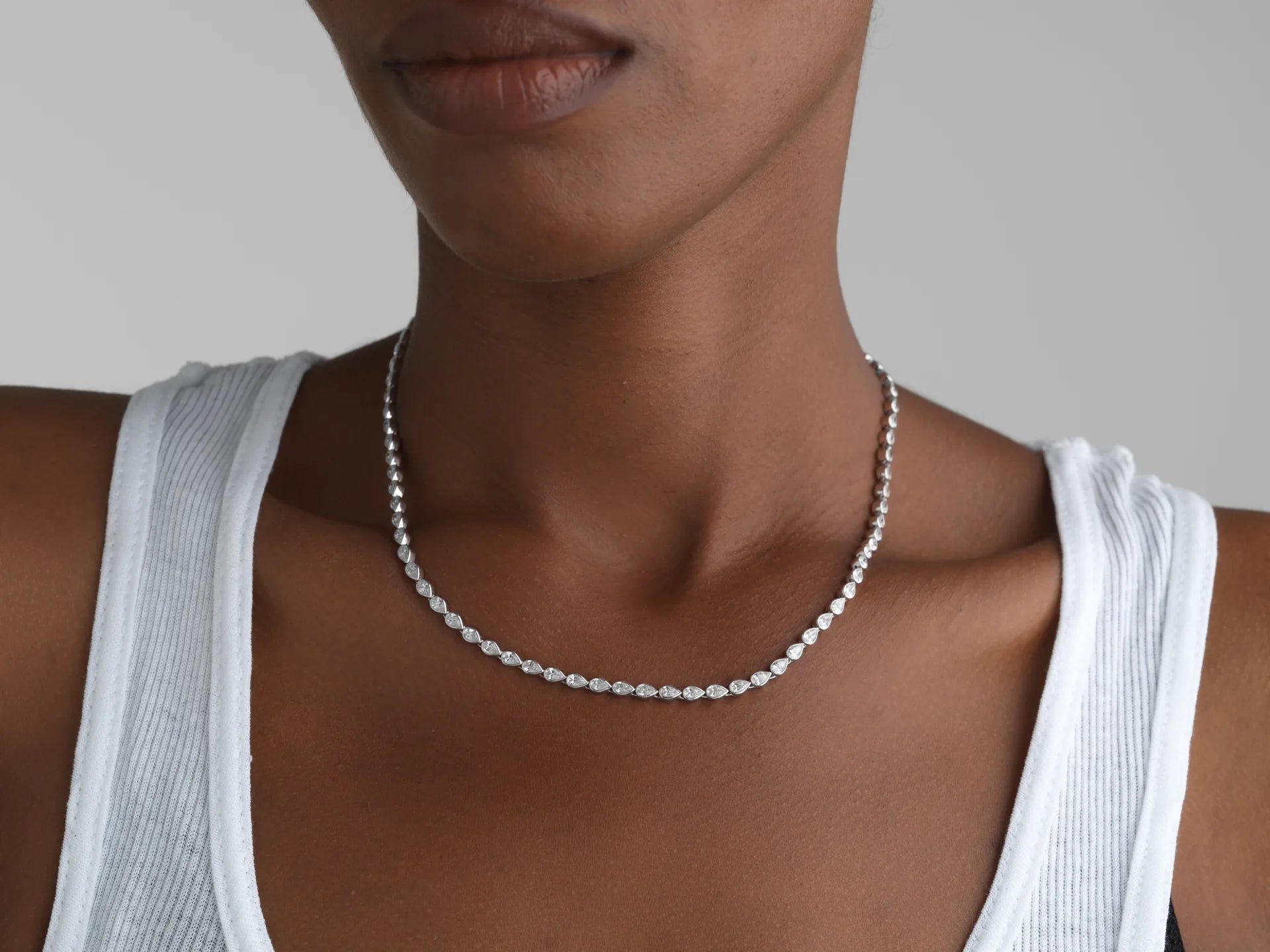 14K gold pear bezel tennis necklace with lab-grown diamonds, worn on a model.