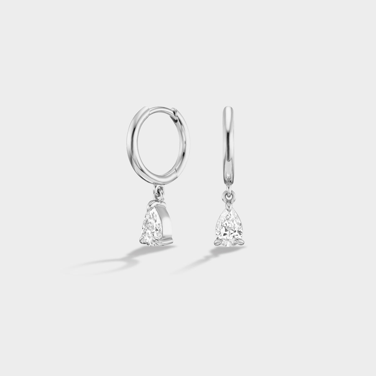 14K white gold huggie earrings with dangling pear-cut lab diamonds, perfect for everyday wear or stacking.