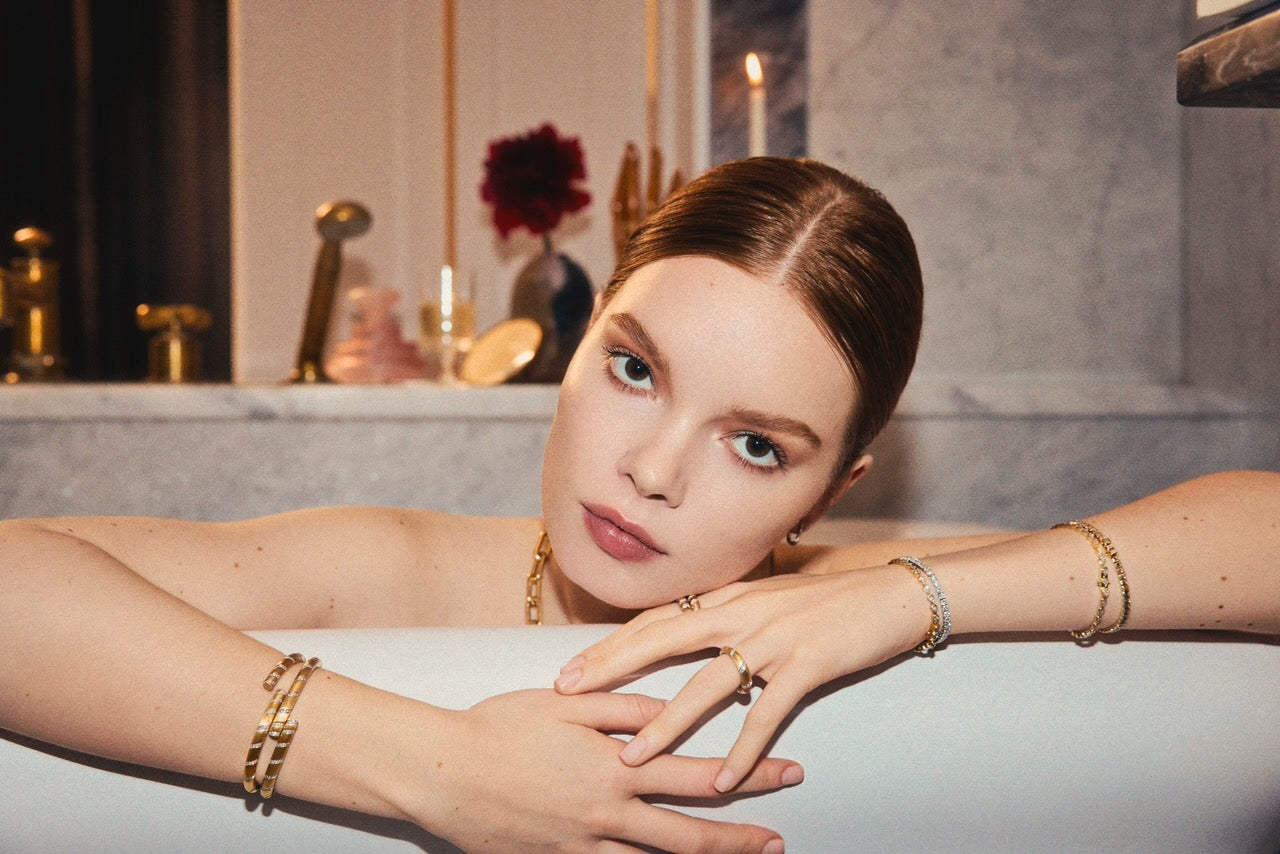 Woman wearing a bold 14k yellow gold satin finish spiral bangle with lab-grown diamonds.
