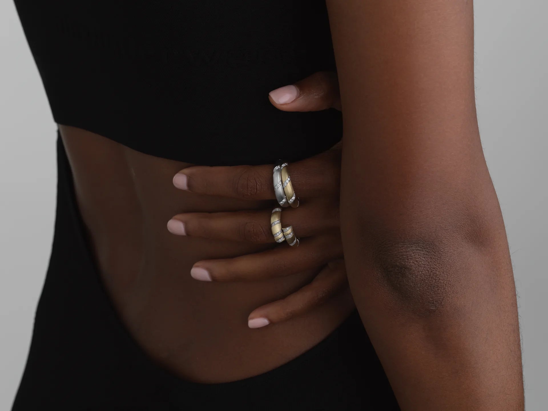 14k white gold twist rings with bezel-set lab-grown diamonds on a hand, perfect for stacking.